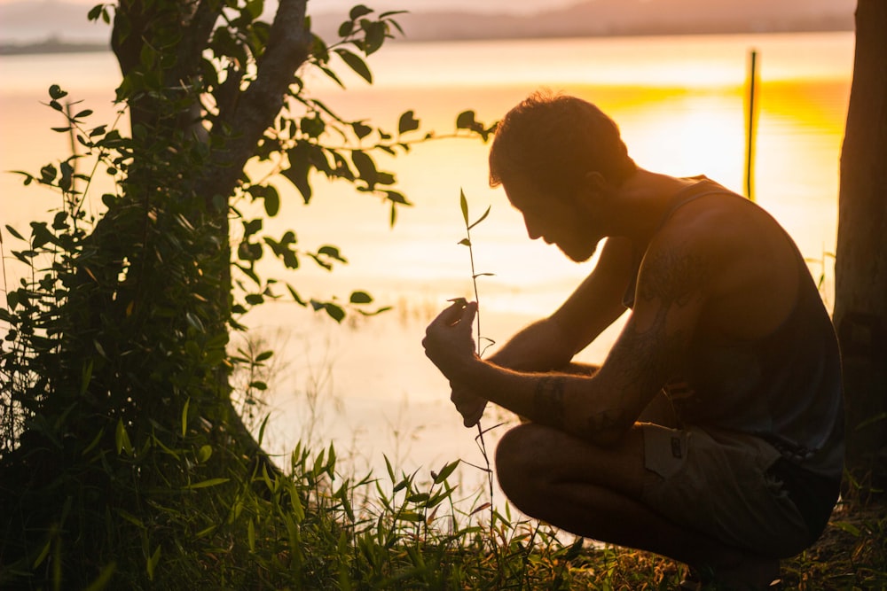 topless man sitting on grass field during daytime