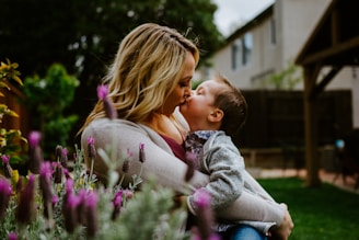 girl in gray jacket kissing girl in gray jacket during daytime
