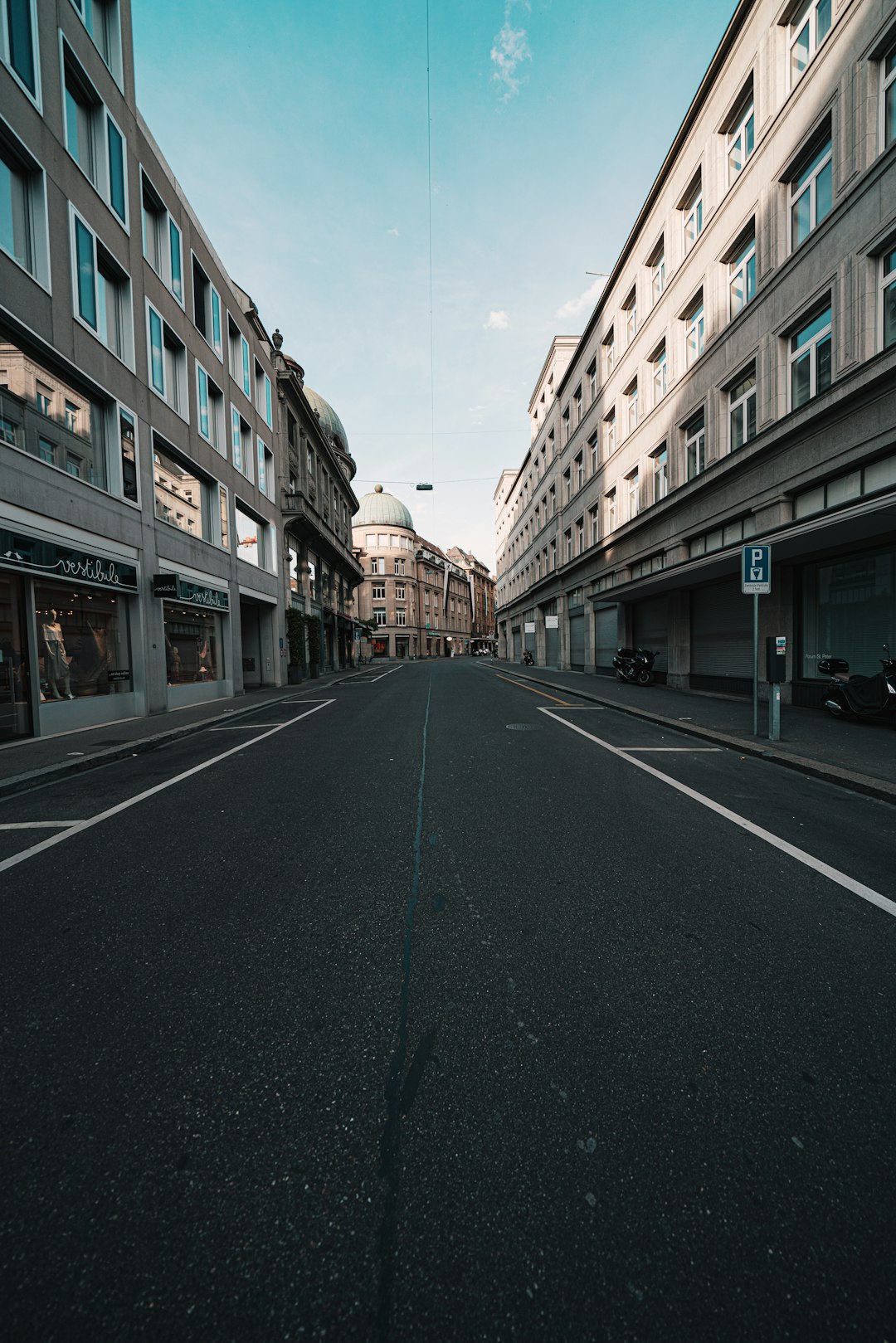 empty road between high rise buildings during daytime