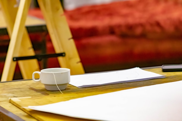 Close-up of a cup of tea next to a notepad with ‘askpaddy’ website open on a tablet screen.