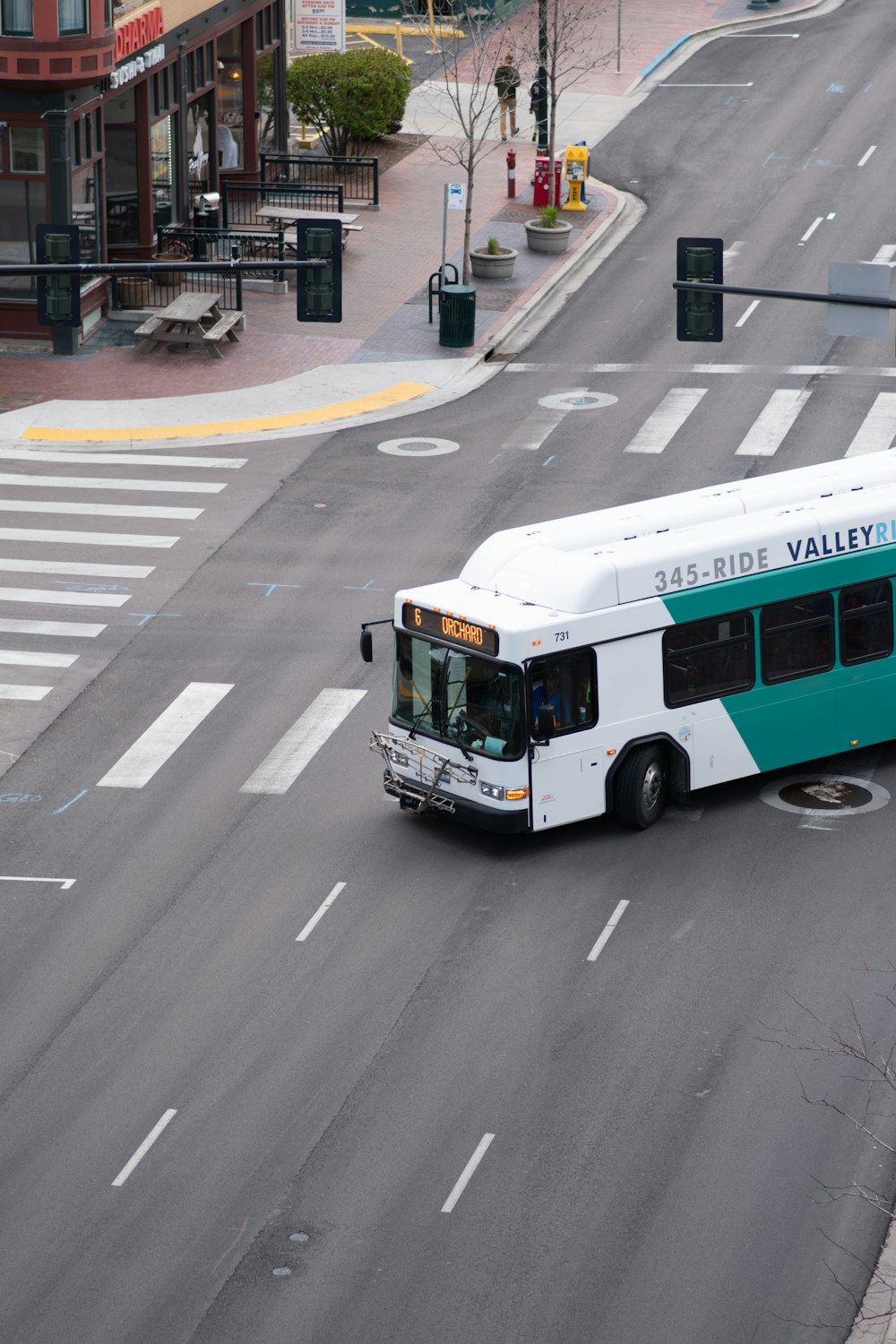 a white and green bus driving down a street