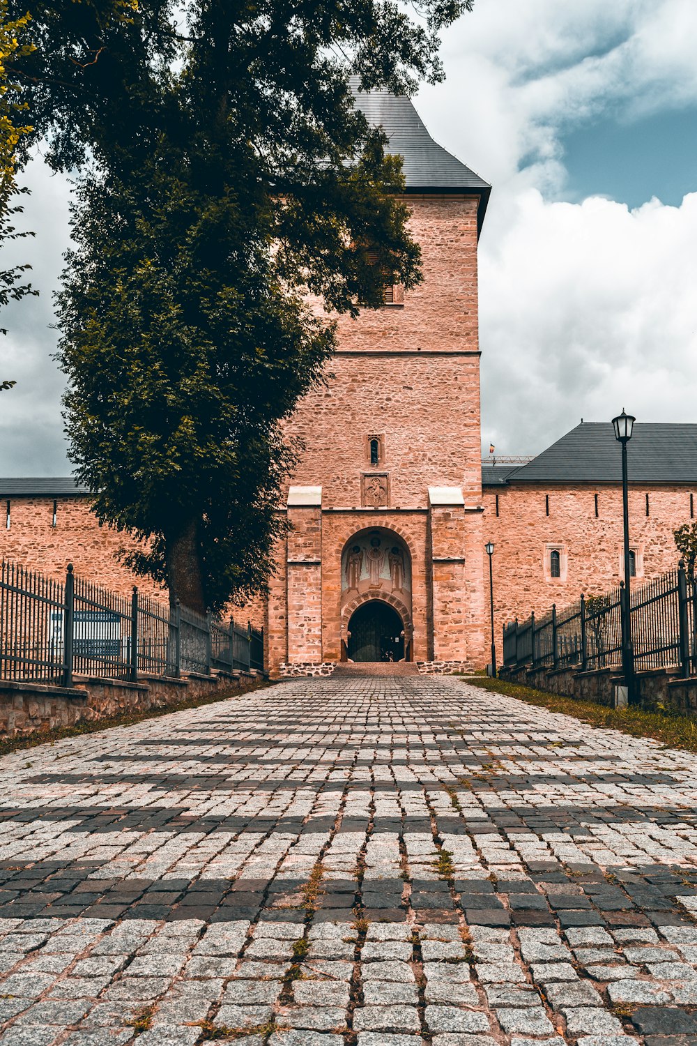 brown brick building near green trees during daytime