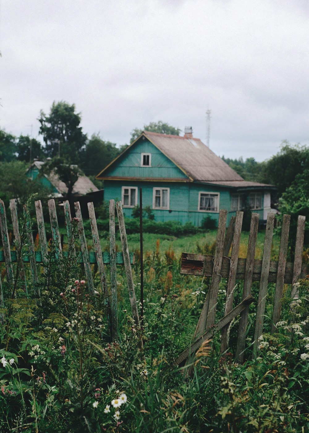 white and brown wooden house near green grass field during daytime