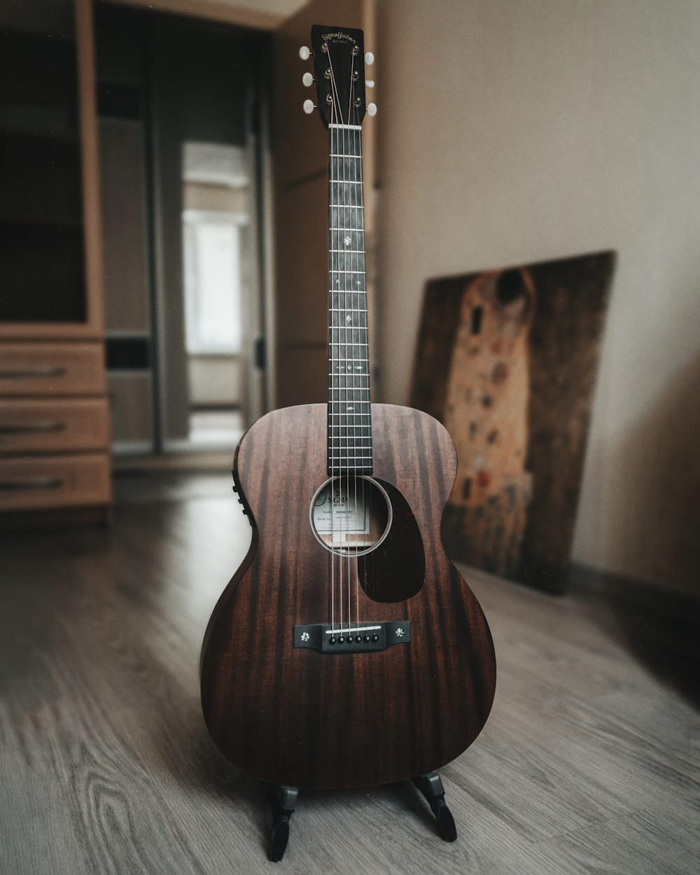 brown acoustic guitar on brown wooden table