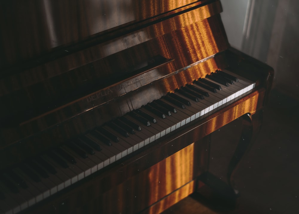 brown wooden upright piano with white and black piano keys