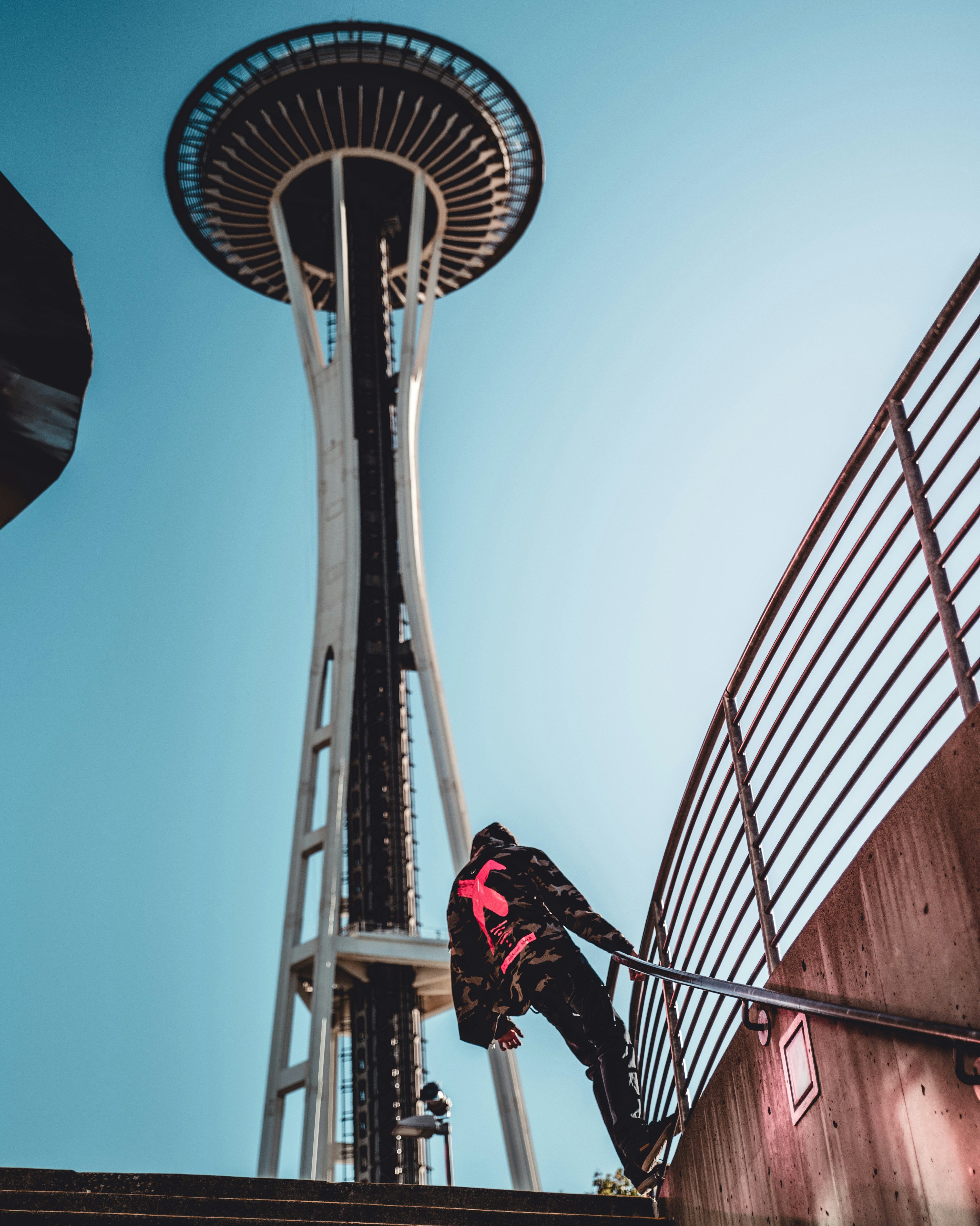 man in red jacket riding bicycle on brown metal bridge during daytime