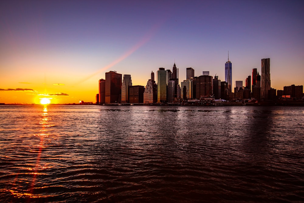 Skyline der Stadt über dem Gewässer während des Sonnenuntergangs