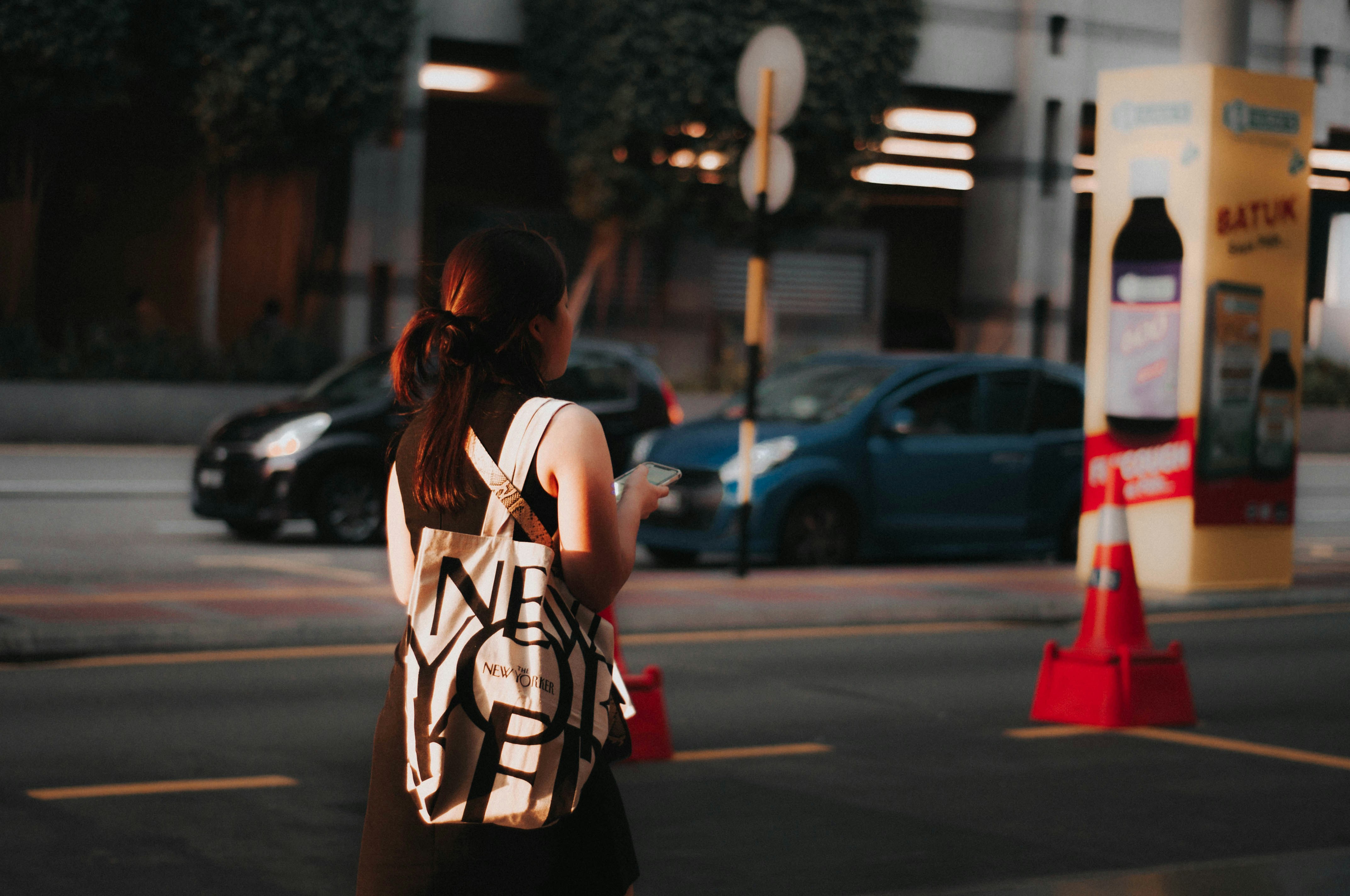 woman in white and black sleeveless dress standing on sidewalk during daytime federal colonial teams background