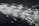 A dynamic burst of light particles streaks across a dark background, creating an abstract and energetic visual effect. The particles appear to be moving at high speed, with varying intensities and sizes, giving the image a sense of motion and depth.