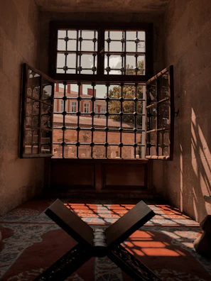 An open door revealing a peaceful room with soft cushions and natural light.