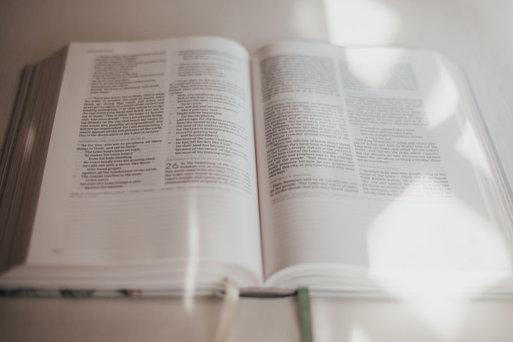 opened book on brown wooden table