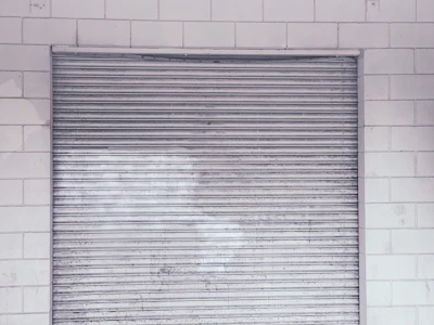 Close-up of a rolling steel door mechanism being repaired by a skilled technician.