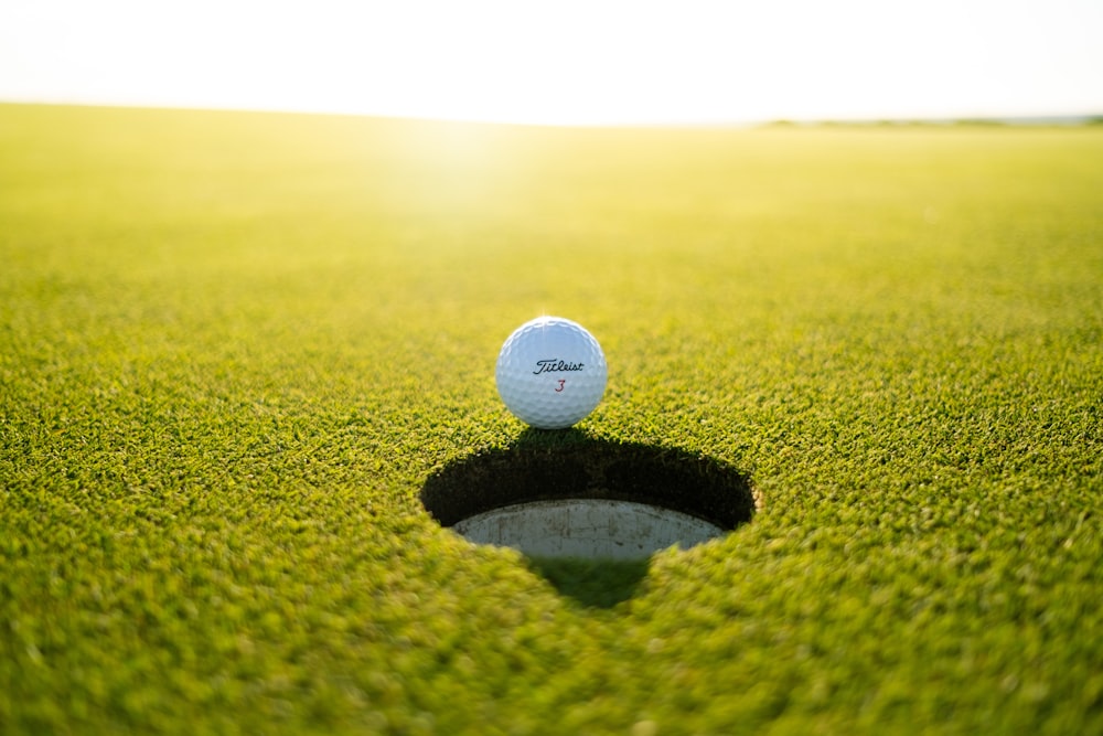 Golfball tagsüber auf grünem Rasen