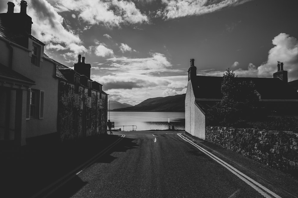 grayscale photo of a house near the river