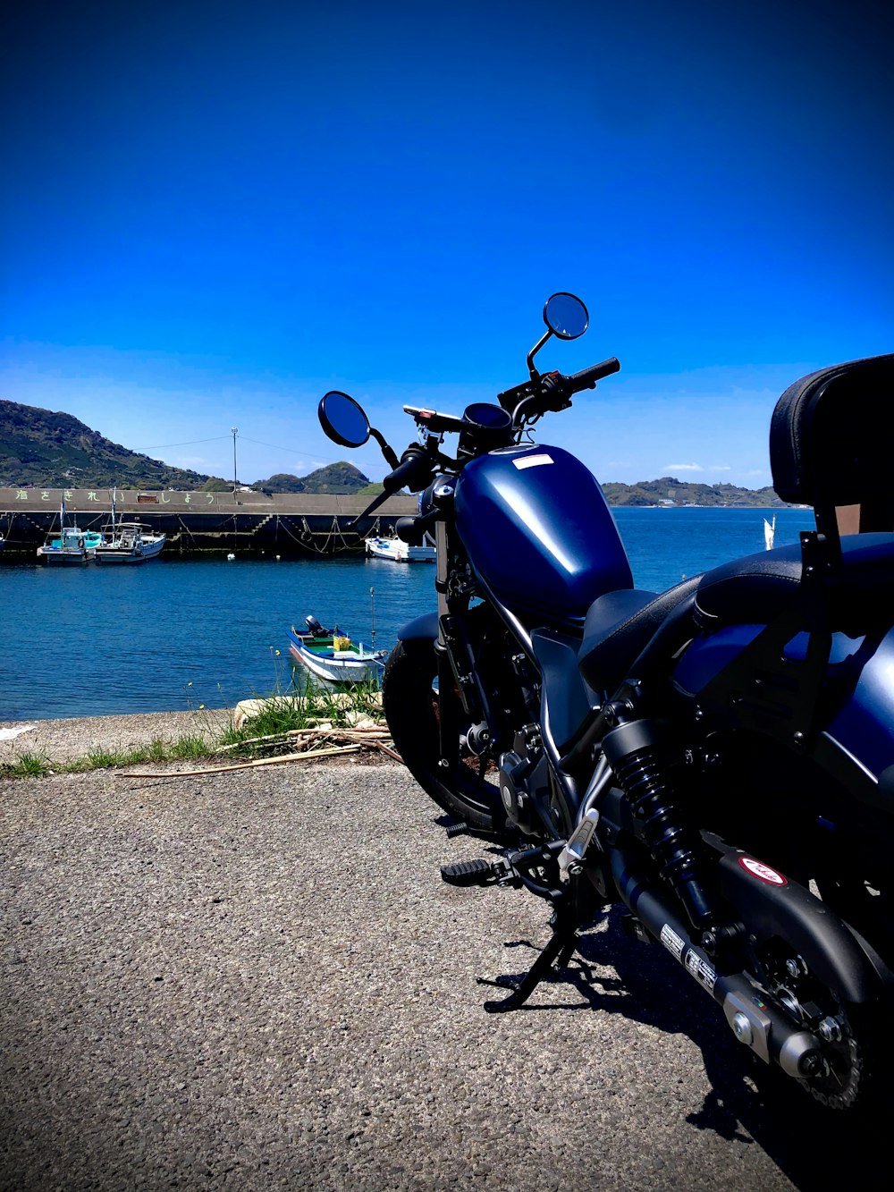 black and silver cruiser motorcycle parked beside body of water during daytime