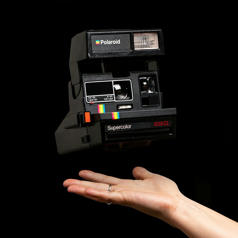 Schwarze Polaroid-Sofortbildkamera auf weißem Hintergrund
