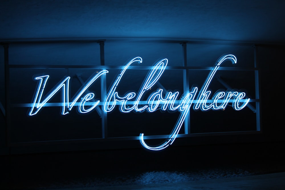 a neon sign that reads welcome here