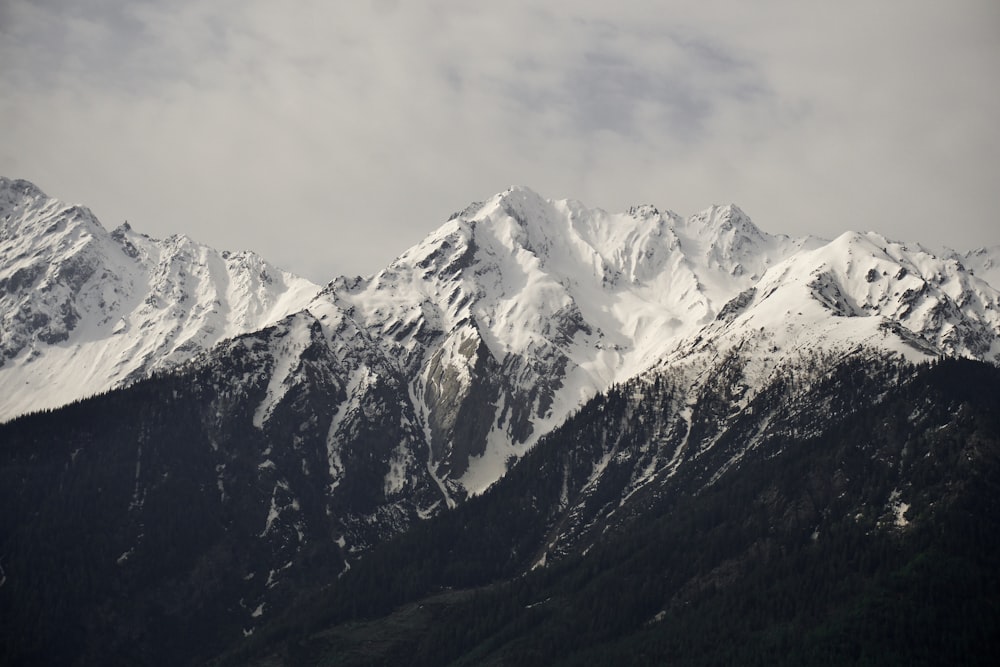 snow covered mountain under cloudy sky during daytime