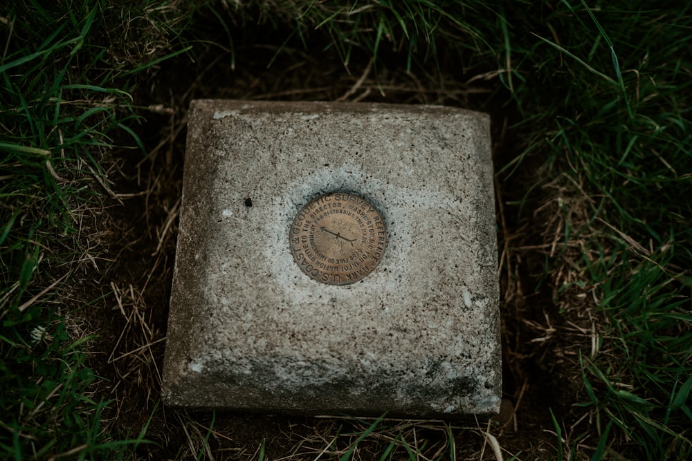grey concrete tomb stone on green grass