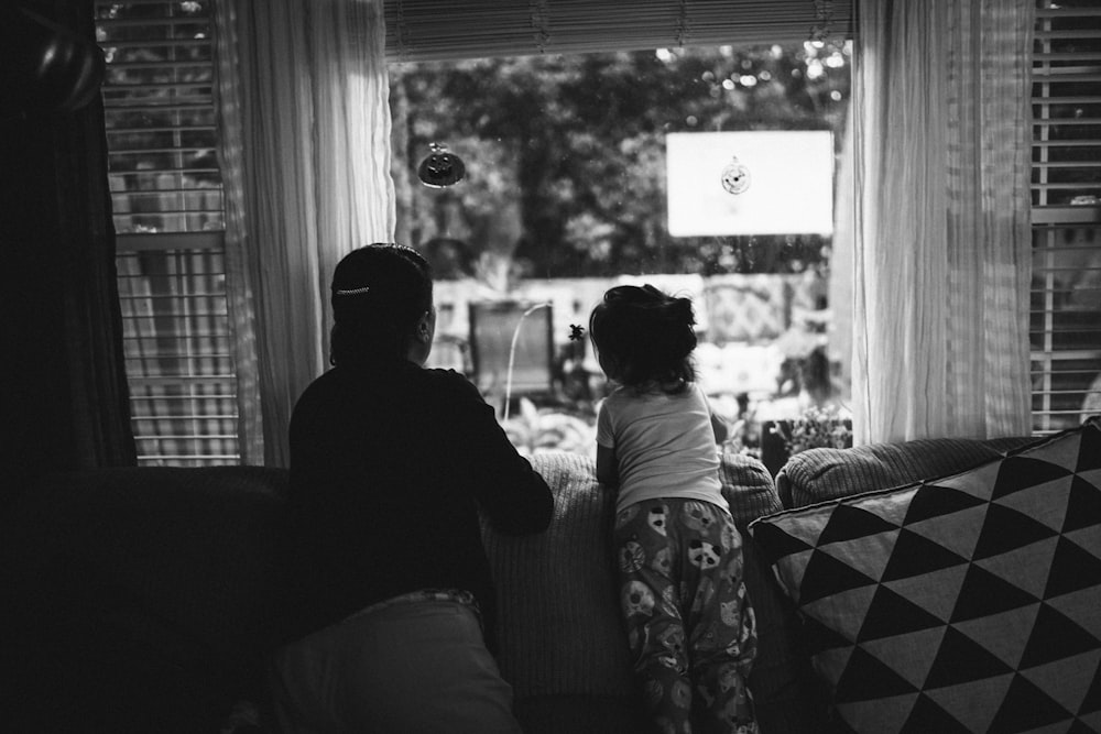 grayscale photo of man and woman sitting on sofa