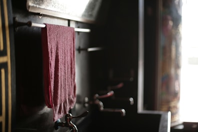A set of hand towels hanging on a rustic wooden rack.