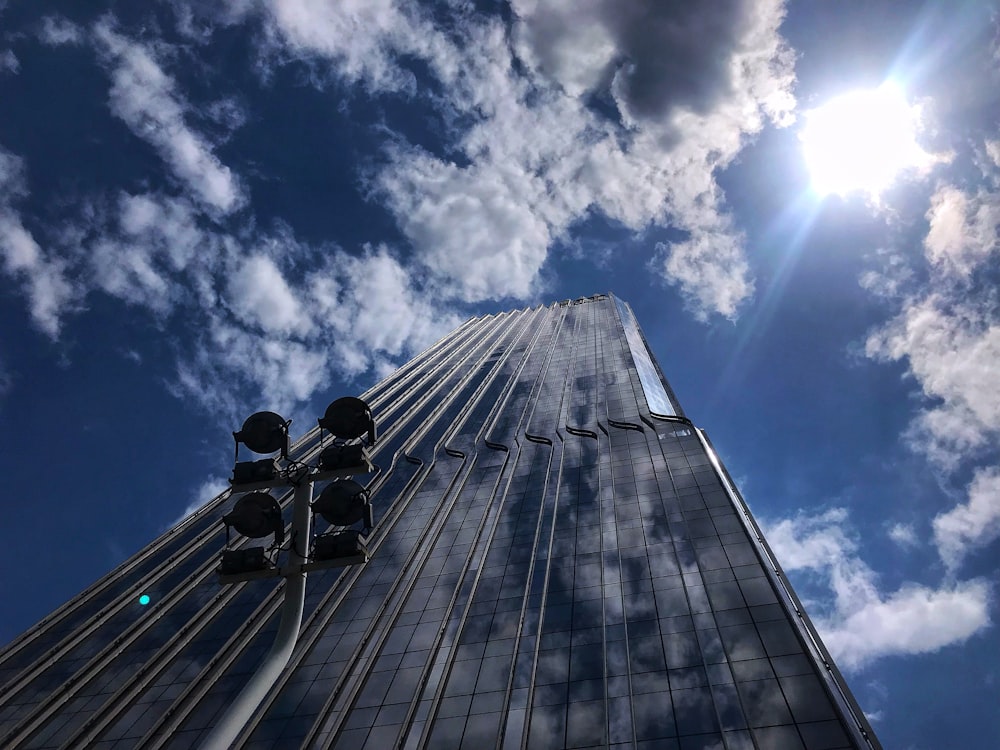 Fotografía de ángulo bajo de un edificio gris bajo el cielo azul durante el día