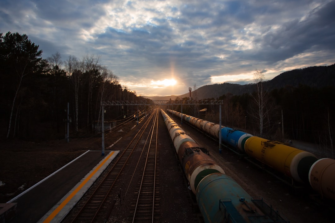 train rail under cloudy sky during daytime