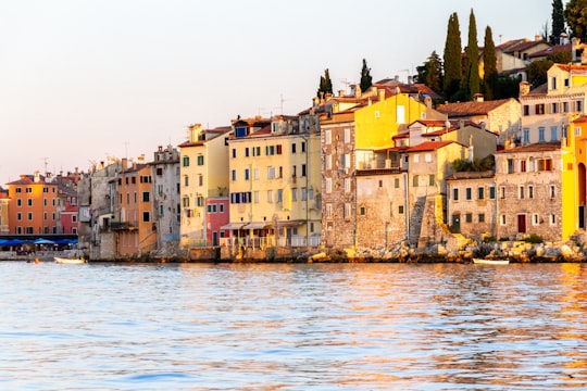 brown concrete building beside body of water during daytime in Rovinj Croatia