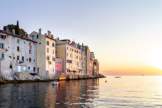 white and brown concrete building beside body of water during daytime in Rovinj Croatia