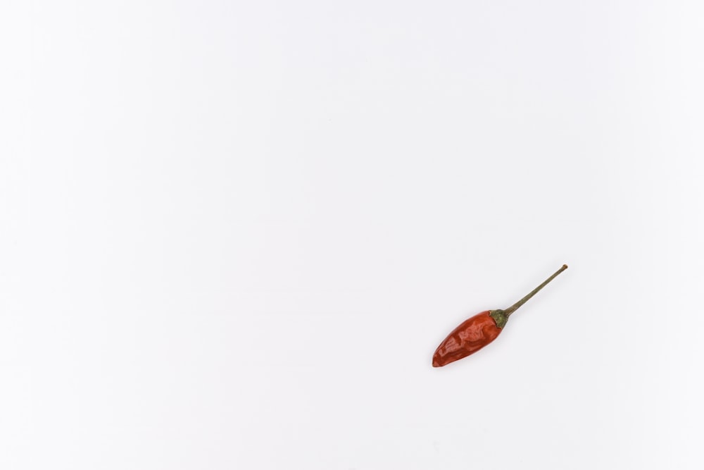 red and silver spoon on white surface