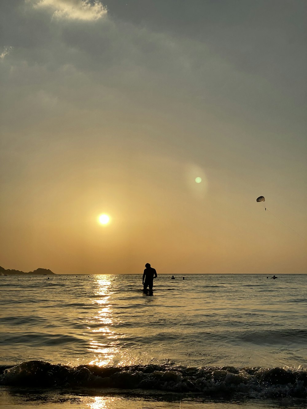 silhouette of man and woman standing on beach during sunset