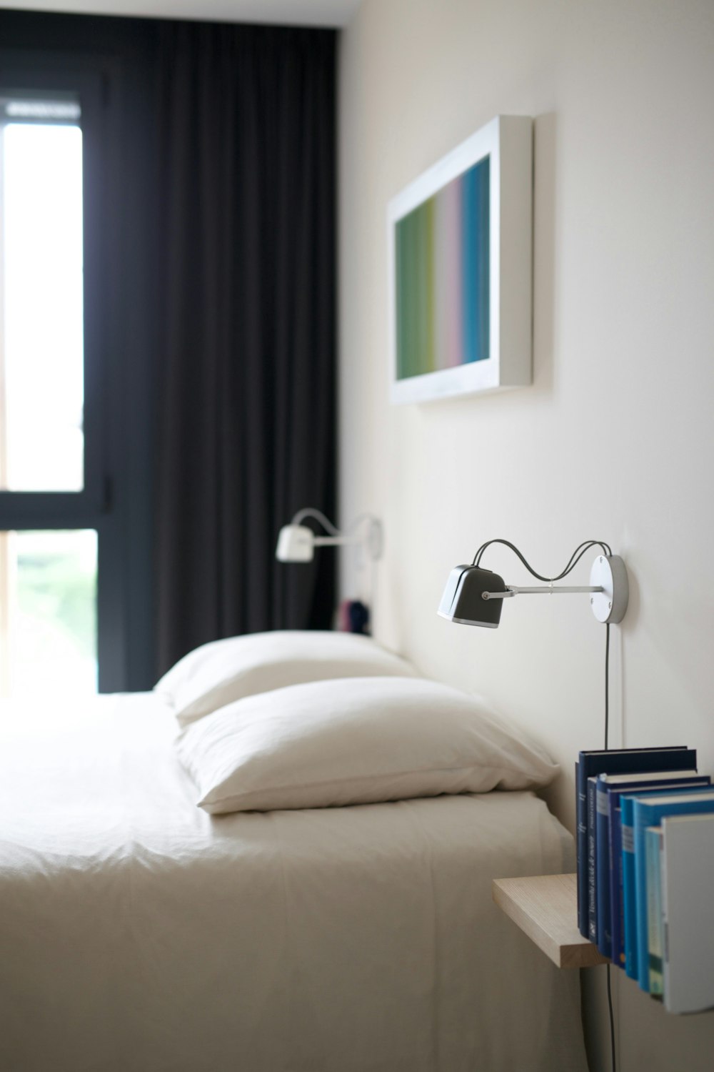 white bed linen near black window curtain