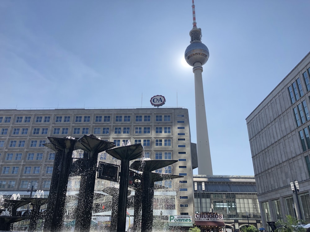 a fountain in front of a building with a tv tower in the background