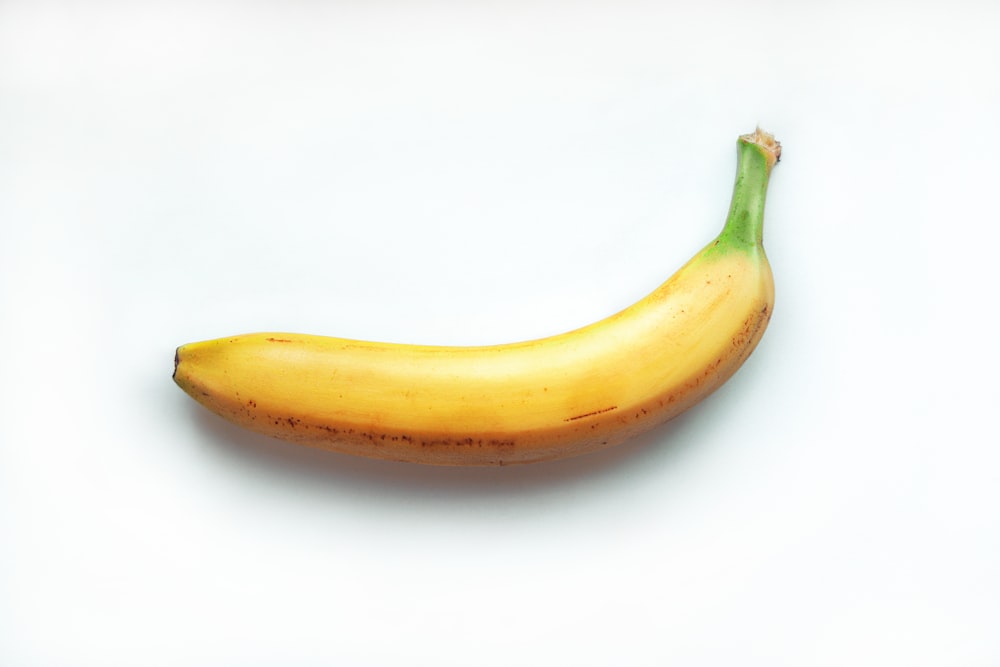 plátano amarillo sobre superficie blanca
