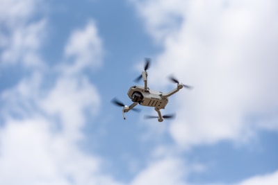 white drone flying in the sky during daytime