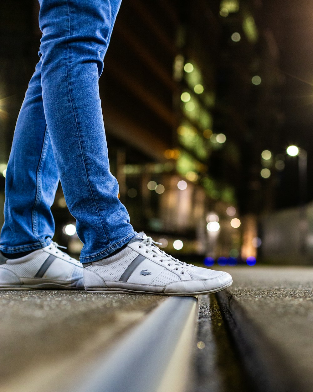 person in blue denim jeans and white converse all star high top sneakers