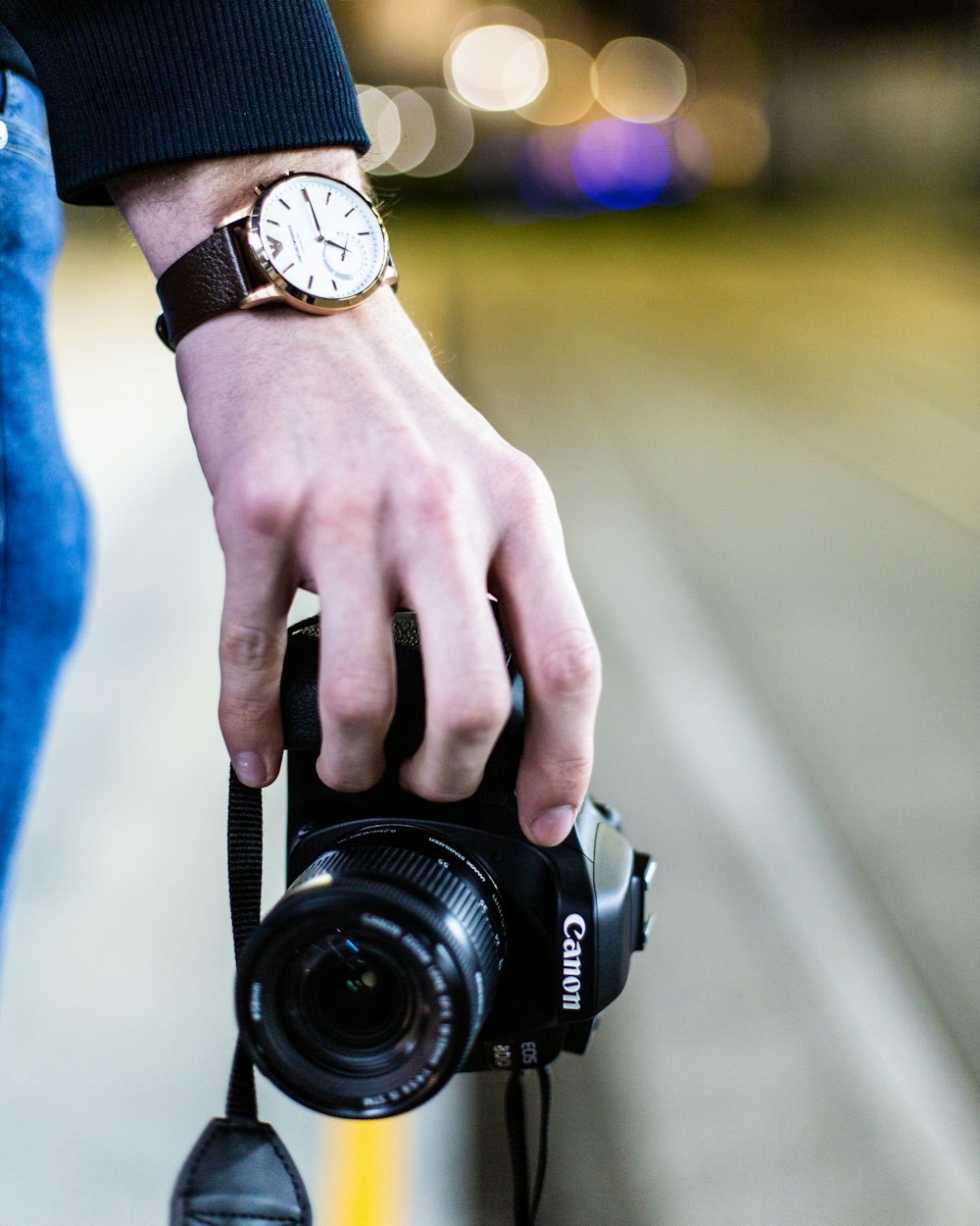 person wearing blue long sleeve shirt holding black dslr camera