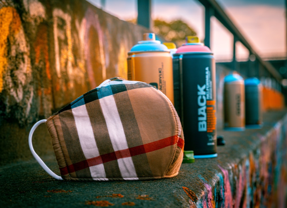 blue and white plaid pouch beside blue and white plastic bottle