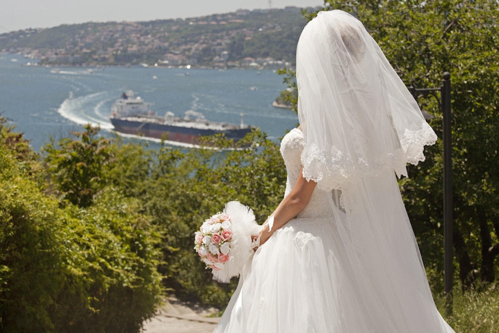 woman in white wedding dress holding bouquet of flowers