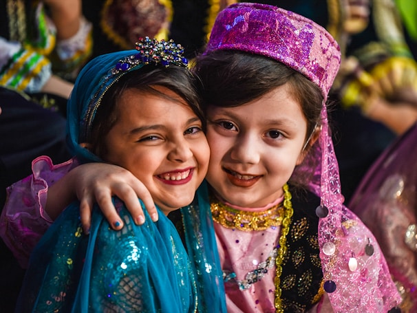 2 girls smiling wearing blue and purple floral dress