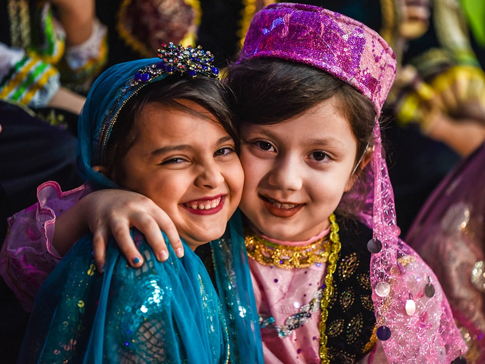 2 girls smiling wearing blue and purple floral dress