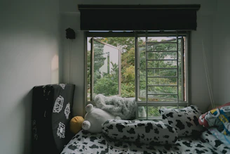 A cozy bed with soft, pastel-colored sheets and a fluffy comforter inviting relaxation.