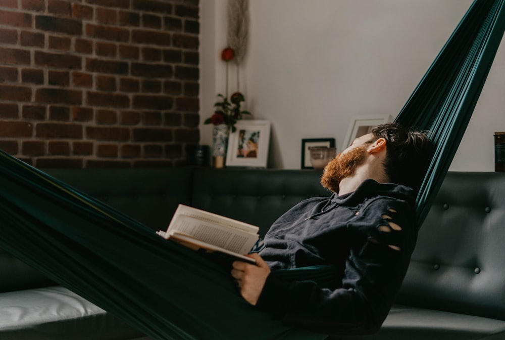 man in black jacket reading book