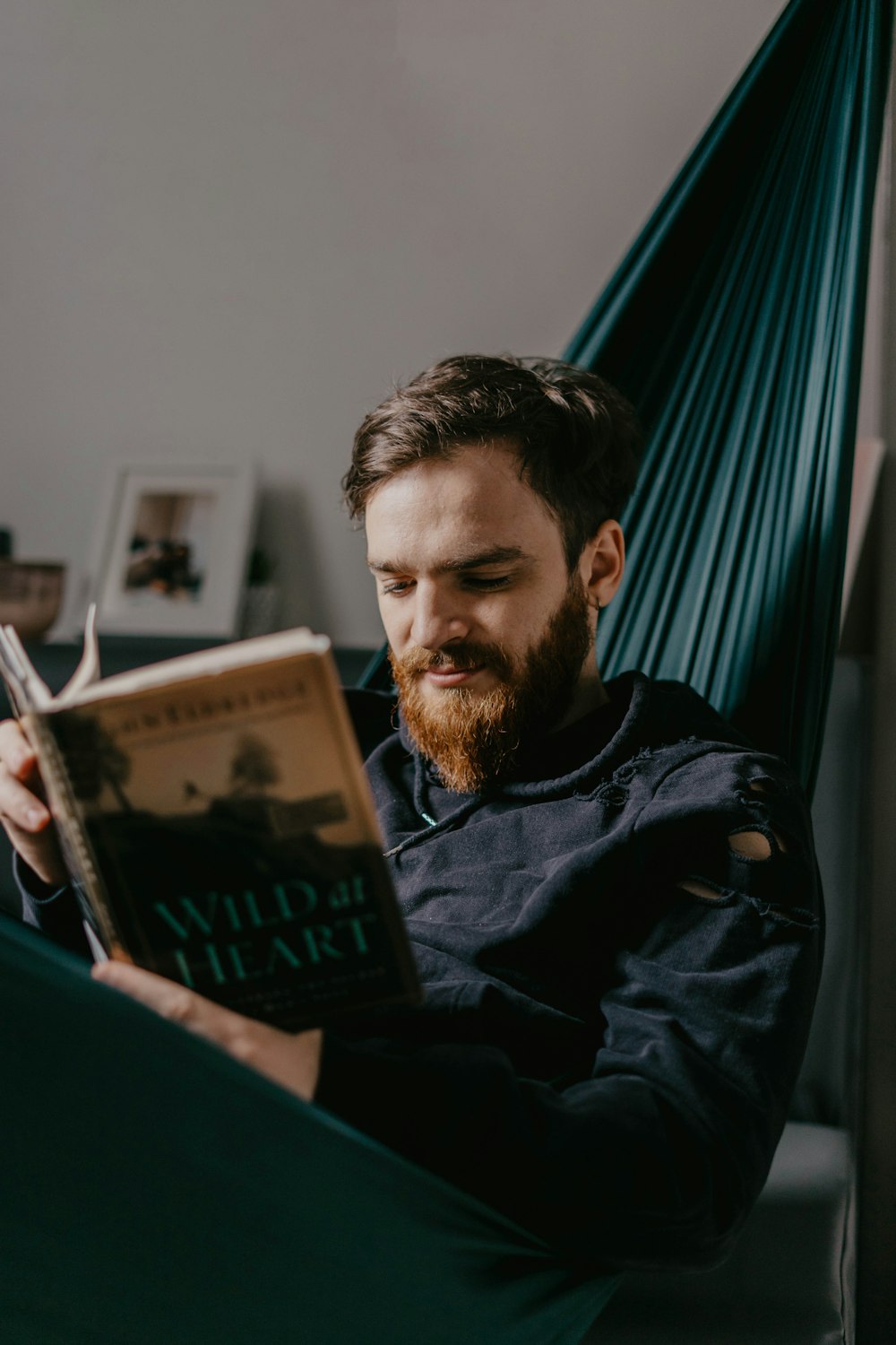 man in black jacket holding book