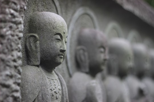 gray concrete statues during daytime in Kamakura Japan