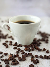 Minimalist illustration of coffee beans and a cup with warm tones.