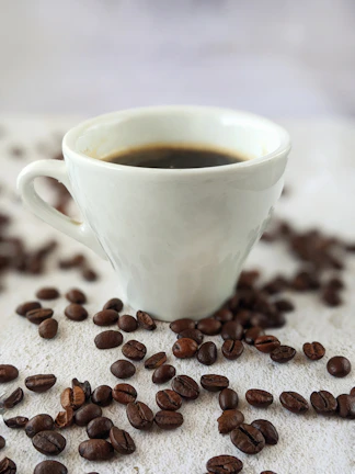 Minimalist coffee setup featuring a steaming cup, beans, and subtle topographic lines on a cream background