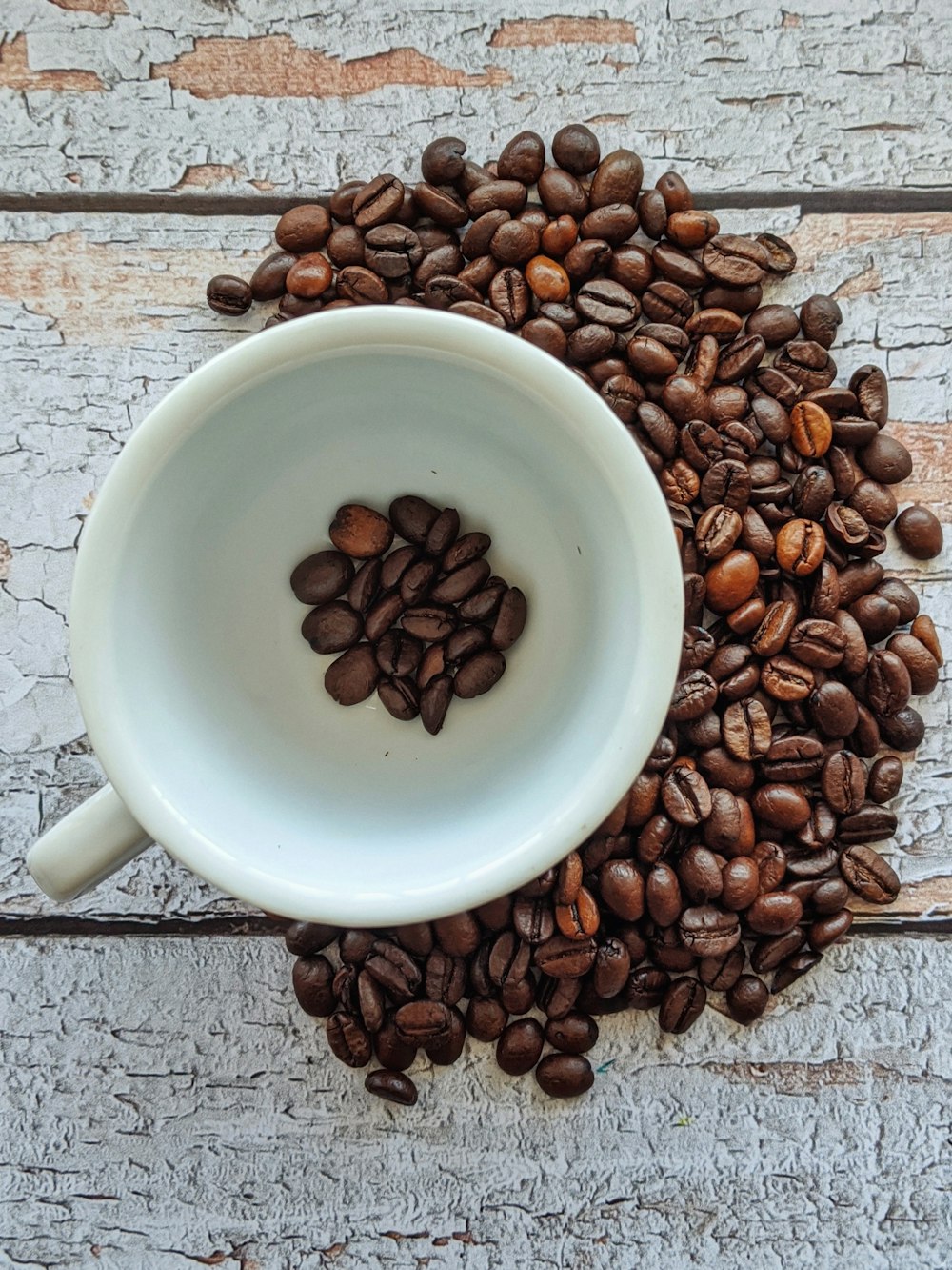 white ceramic mug with coffee beans