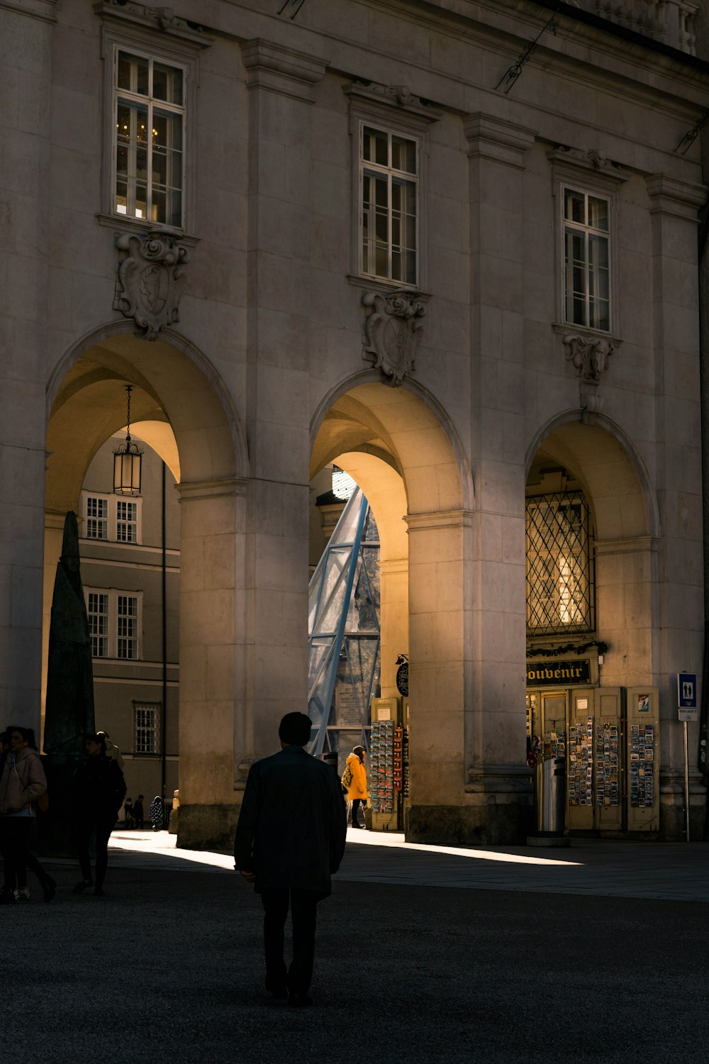 a man walking down a street next to a tall building