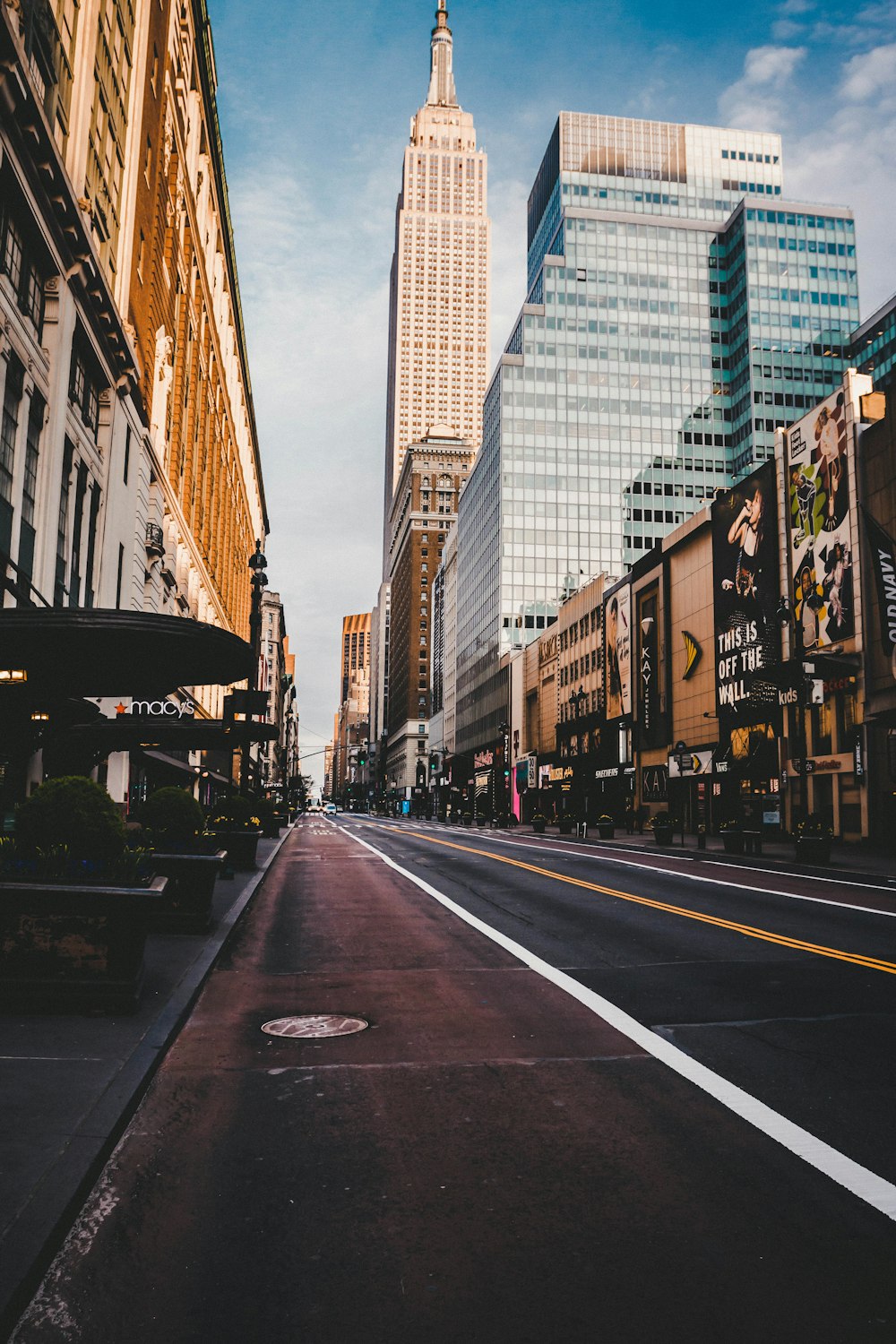 gray concrete road between high rise buildings during daytime